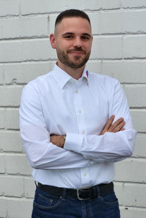 Yannik Kopp steht mit verschränkten Armen vor der Hauswand von GEDE GmbH