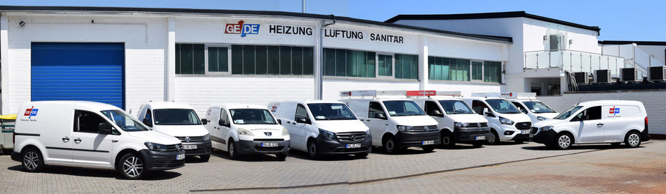 Neun weiße Fahrzeuge und Transporter stehen auf dem Firmengelände der GEDE GmbH